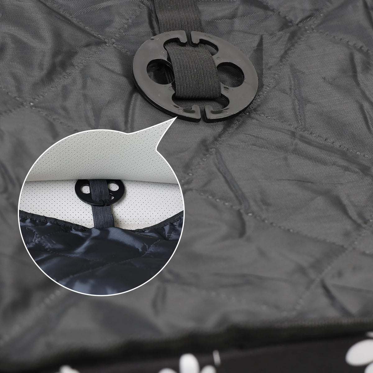 Close-up of the elastic strap and black clip on the quilted back of a portable dog car seat, with a round inset view